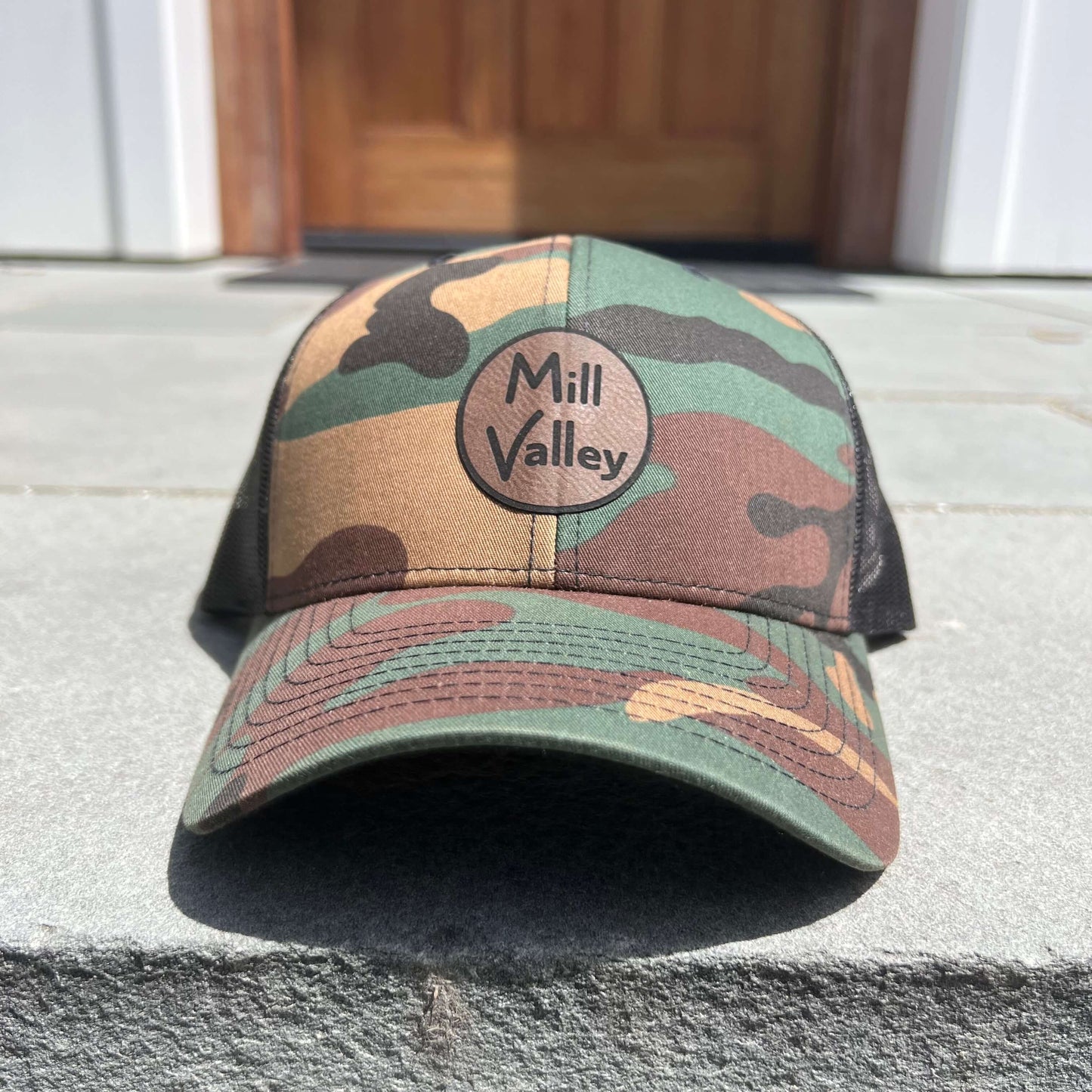 Lowkey Local Mill Valley trucker hat in camo print with a circular logo patch and black mesh back