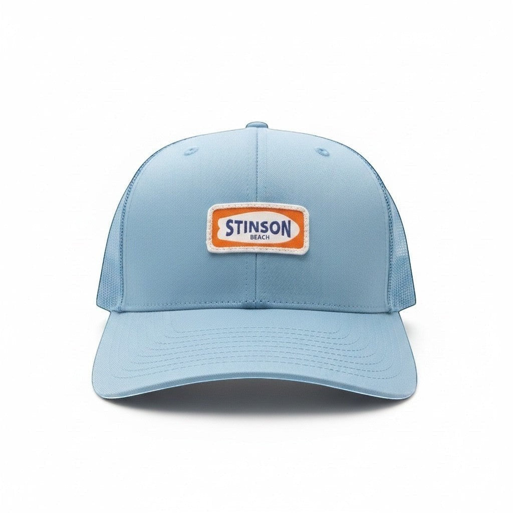 Stinson beach trucker hat in carolina blue with orange and white surfboard patch