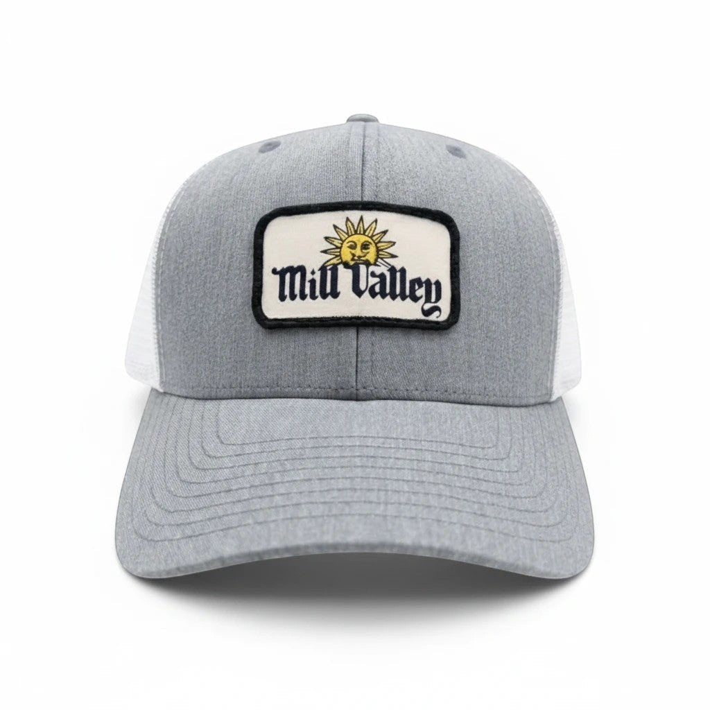 Mill Valley trucker hat with heather gray front, white mesh back, and sun patch on a structured 6 panel hat