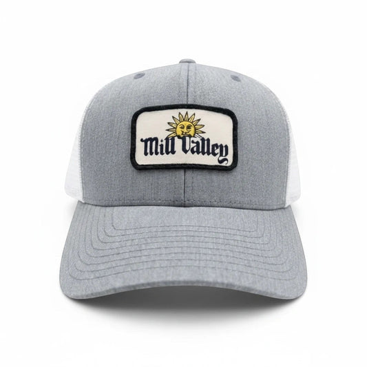 Mill Valley trucker hat with heather gray front, white mesh back, and sun patch on a structured 6 panel hat