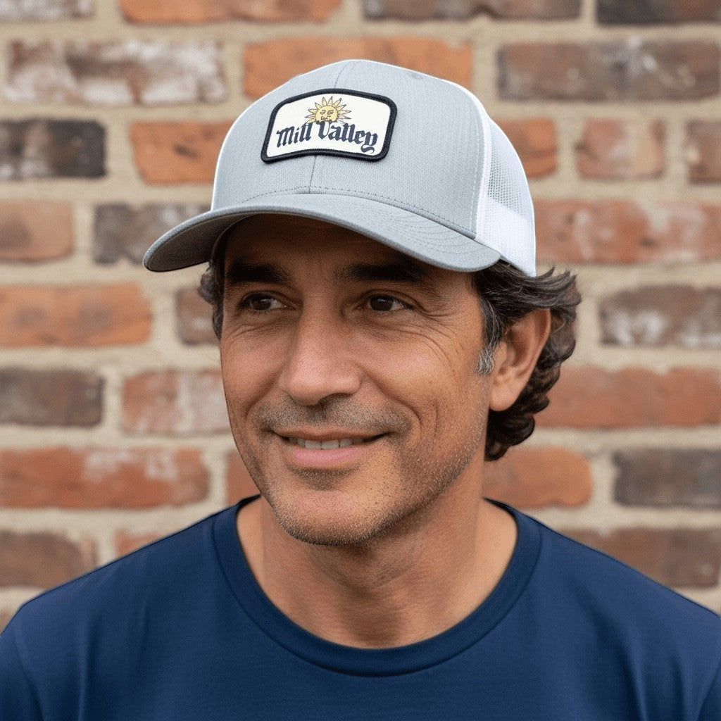 Lowkey Local Mill Valley trucker hat in heather gray with white mesh back and sun patch worn by a man