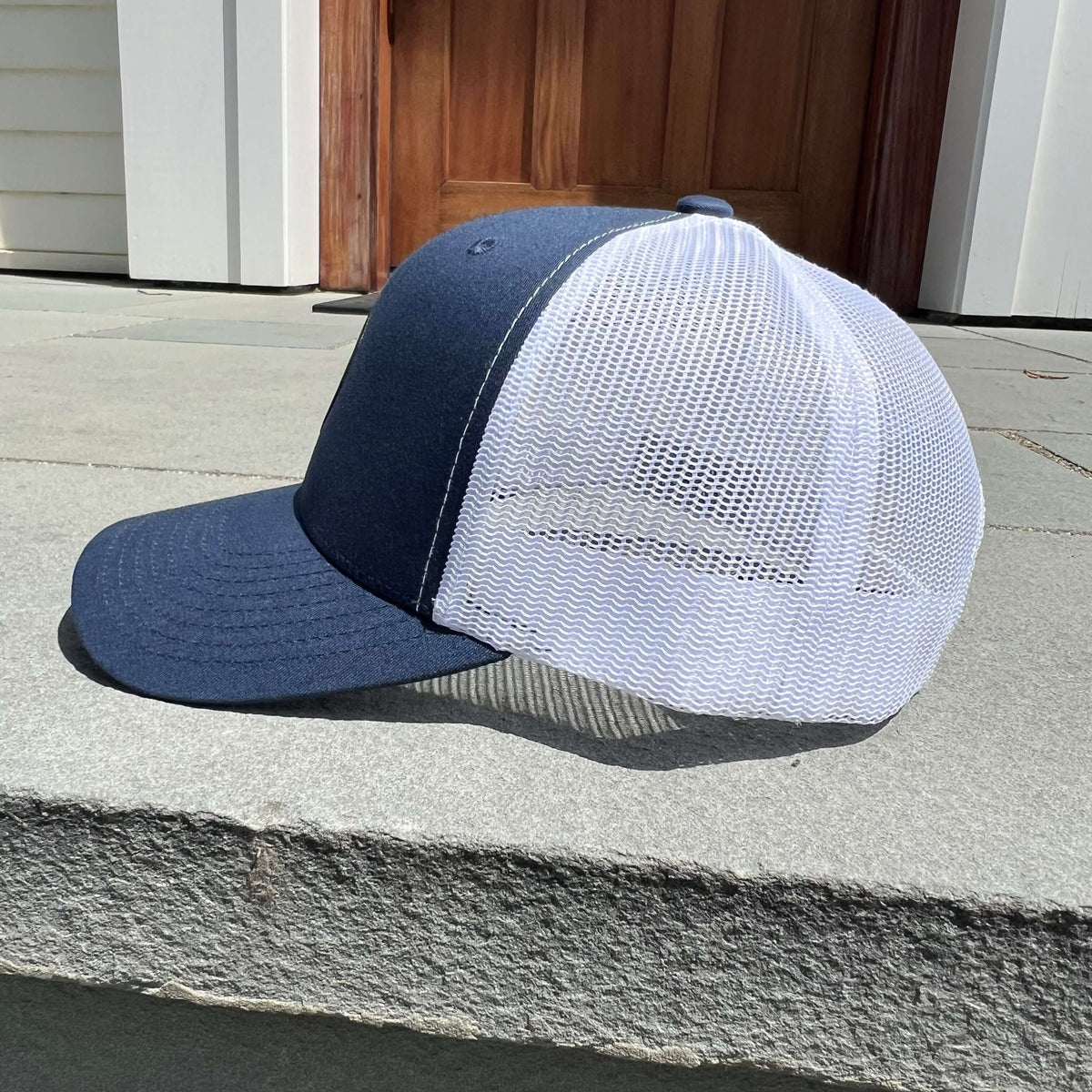 Lowkey Local navy blue and white mesh trucker hat with a structured 6-panel design and adjustable snapback closure.