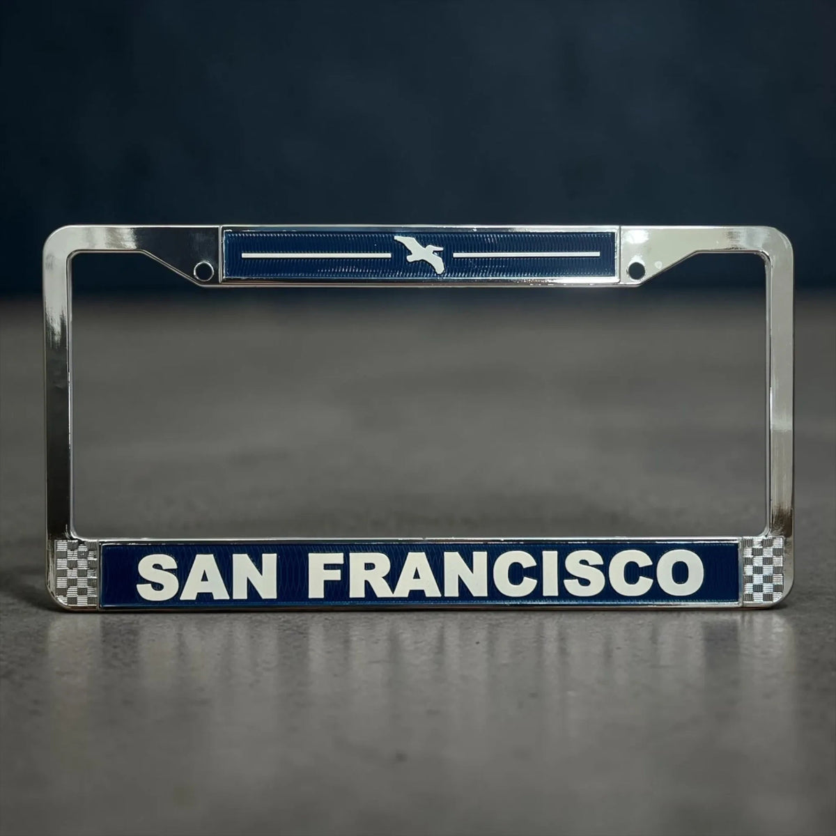 Lowkey Local San Francisco license plate frame in navy blue die cast metal with raised white lettering and pelican icon