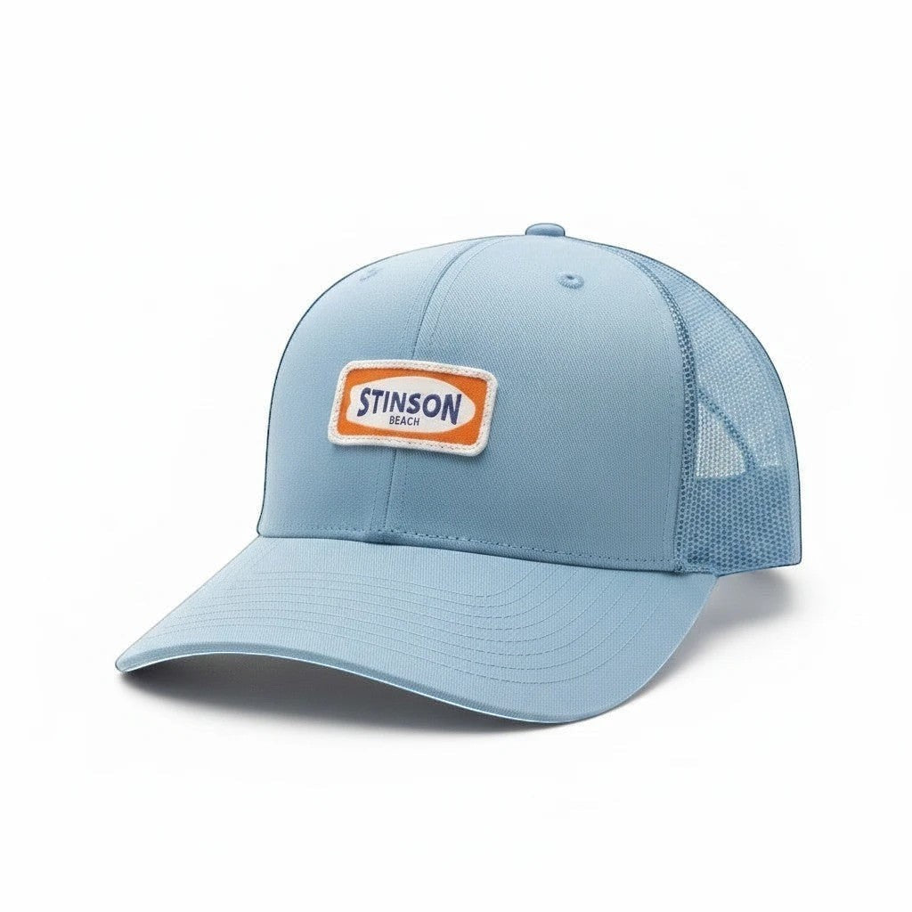 Stinson beach trucker hat in carolina blue with orange and white surfboard patch side angle