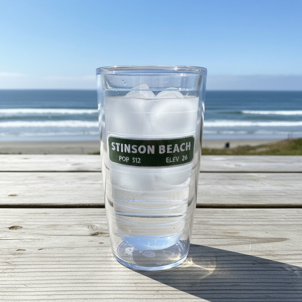 Lowkey Local Stinson Beach Tervis tumbler filled with ice, featuring double-wall insulation on a beachside table.